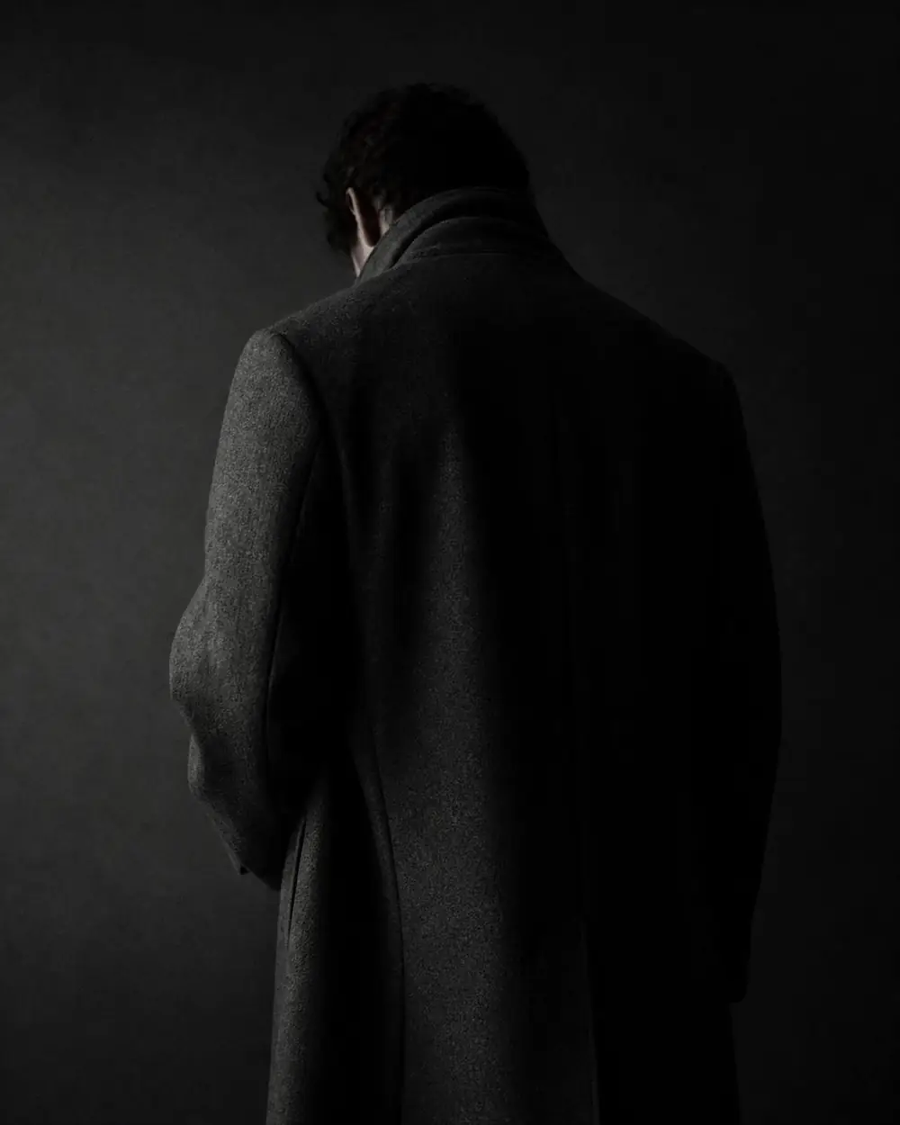 Silhouette of an unbranded charcoal overcoat in low light